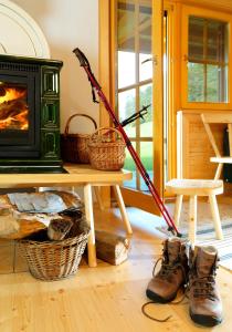 a room with a fireplace and boots and a stove at Farm Stay Pirc in Laško