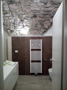 a bathroom with a stone ceiling with a toilet and a sink at Appartamento Monte Misone in Fiavè