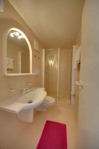 W łazience znajduje się umywalka, toaleta i lustro. w obiekcie Gasthaus Straub w mieście Grettstadt