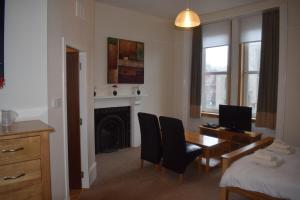 Habitación con escritorio, cama, mesa y sillas. en Cheers Cafe Bar & Tavern en Fraserburgh