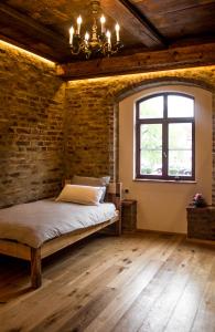 a bedroom with a bed and a brick wall at Wirgarten Antik Hotel in Dingolfing