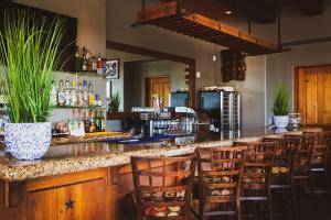 a bar with wooden chairs and a counter with alcohol at Inn at Eagle Mountain in Scottsdale