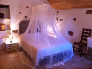 - une chambre avec un lit et une moustiquaire dans l'établissement Caseddu di Chjarastella, à Figari