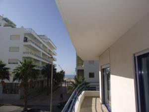 uitzicht op het strand vanaf het balkon van een gebouw bij Apartamentos Carteia in Quarteira