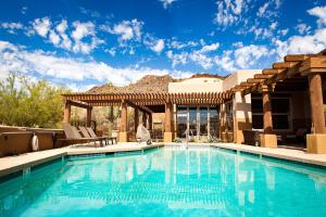 a swimming pool in front of a house with a mountain at Inn at Eagle Mountain in Scottsdale