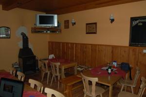 a dining room with tables and chairs and a television at Pension Pod Hrádečkem in Höllenhäuser