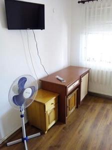a room with a desk and a fan in a room at Morski Rai Rooms in Byala