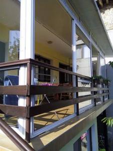 a balcony of a house with a chair on it at Morski Rai Rooms in Byala