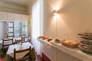 una stanza con un tavolo con sopra del cibo di Hotel d'Azeglio Firenze a Firenze