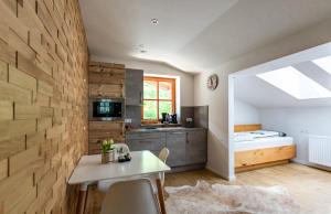 a kitchen with a table and a room with a bed at Alpenhaus Dachstein.Zauber in Abtenau