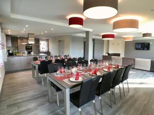 a dining room with a long table and black chairs at Villa Natica in Butgenbach