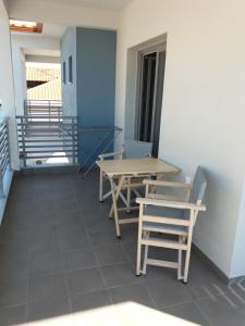 a room with two tables and chairs and stairs at Nissos Rooms Ammouliani in Ammouliani +12 photos