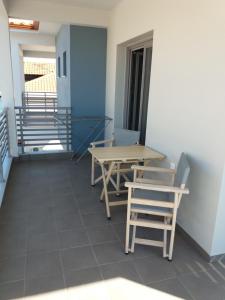 
a dining room table with chairs and a table with chairs at Nissos Rooms Ammouliani in Ammouliani
