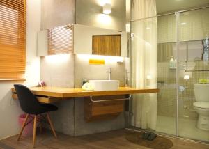 安平的住宿－Jin Flower Homestay，一间带水槽和玻璃淋浴的浴室