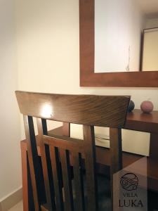 a wooden chair in front of a desk with a mirror at Apartments Villa Luka in Sveti Stefan
