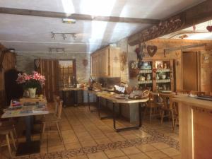 a kitchen with wooden cabinets and tables and chairs at Au Bois de Lune in Châtel