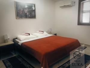 a bed in a room with a picture on the wall at Apartments Villa Luka in Sveti Stefan