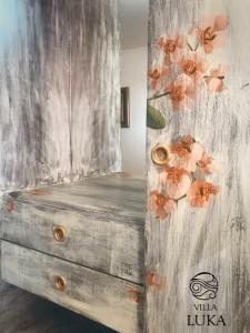 a wooden dresser with a painting of flowers on it at Apartments Villa Luka in Sveti Stefan