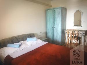 a bedroom with a large bed and a blue cabinet at Apartments Villa Luka in Sveti Stefan