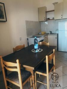 a kitchen with a table with a bottle of water on it at Apartments Villa Luka in Sveti Stefan
