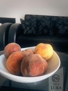 a bowl of peaches and pears on a plate at Apartments Villa Luka in Sveti Stefan