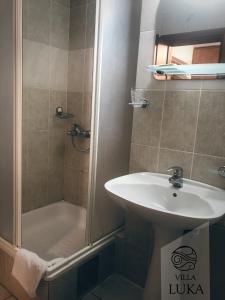 a bathroom with a sink and a shower at Apartments Villa Luka in Sveti Stefan