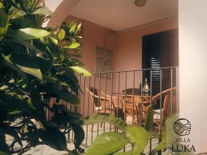 a balcony with a table and a chair in a room at Apartments Villa Luka in Sveti Stefan