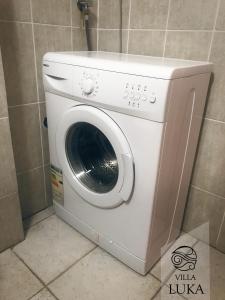 a white washing machine sitting in a bathroom at Apartments Villa Luka in Sveti Stefan