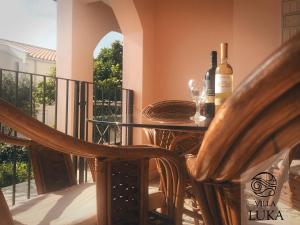 a table with two bottles of wine on a balcony at Apartments Villa Luka in Sveti Stefan
