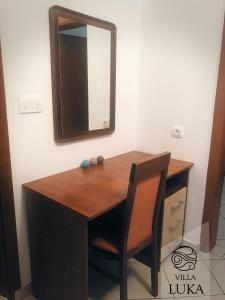 a wooden desk with a mirror and a chair at Apartments Villa Luka in Sveti Stefan