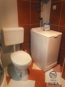 a bathroom with a white toilet in a room at Apartments Villa Luka in Sveti Stefan