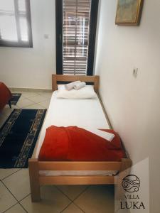 a bedroom with a bed with a red blanket at Apartments Villa Luka in Sveti Stefan