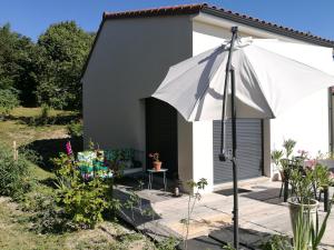 a white umbrella in front of a house at L'Alphonsine in Veyre-Monton