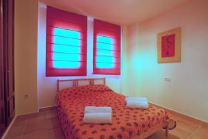 ein Schlafzimmer mit einem roten Bett mit zwei weißen Kissen in der Unterkunft Alcores de Calahonda in Mijas Costa