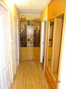 a hallway with wooden floors and a closet with glass doors at Briedis un partneri in Cēsis