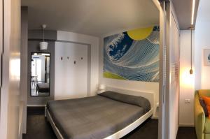 a bedroom with a bed and a painting on the wall at Mizzika Vacanze in Castellammare del Golfo