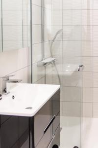 baño blanco con ducha y lavamanos en les appartements du 10, en Rochefort