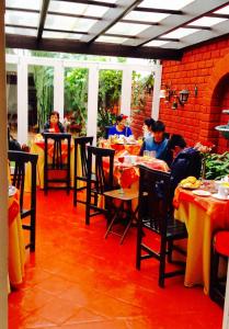 a group of people sitting at tables in a restaurant at Residencial Carlos in Lima