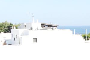 レウカにあるCasa santa mariaの海を背景にした白い家