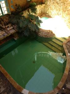 una vista aérea de una piscina de agua con palmeras en Hotel Los Geranios, en Duitama