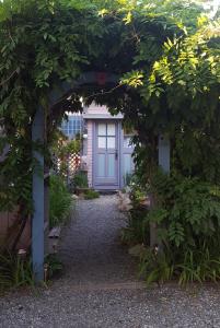einen Torbogen mit einer lila Tür in einem Garten in der Unterkunft The Oak Bluffs Inn in Oak Bluffs