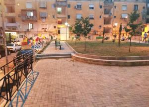 una pasarela de ladrillo frente a un gran edificio en Downtown Tirana Apartments, en Tirana