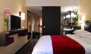 a hotel room with a bed and a television at Eastwest Hôtel in Geneva