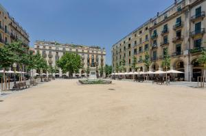 a large plaza in a city with tables and umbrellas at Santa Clara Apartments in Girona