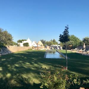 un parque con un estanque en medio de un campo en Fatuaria en Cisternino