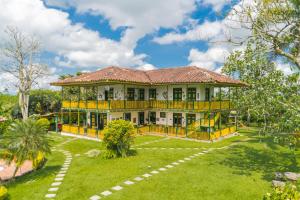a large yellow house with a playground in the yard at Finca Hotel el Palmar in Montenegro