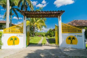 a gate to a villa with palm trees at Finca Hotel el Palmar in Montenegro