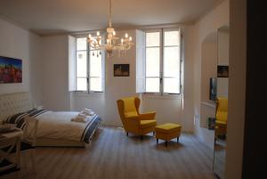 ein Schlafzimmer mit einem Bett, einem Stuhl und einem Kronleuchter in der Unterkunft Berardi Palace - Vigna Nuova Apartment in Florenz