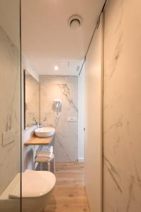 y baño con aseo blanco y lavamanos. en Hotel SempreFisterra, en Finisterre