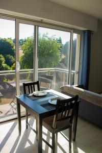 een eettafel en stoelen voor een raam bij T1 tout équipé avec balcon & parking ! in Cherbourg en Cotentin